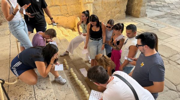 Equipo resolviendo una prueba de ingenio con velas en el monasterio
