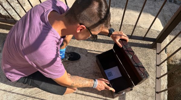 Participante abriendo un cofre durante el escape room en el monasterio