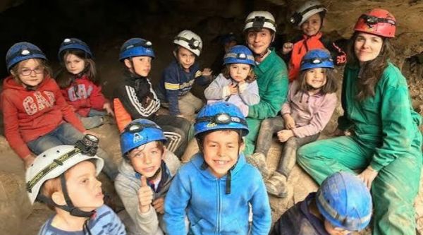 Escolares con casco dentro de una cueva